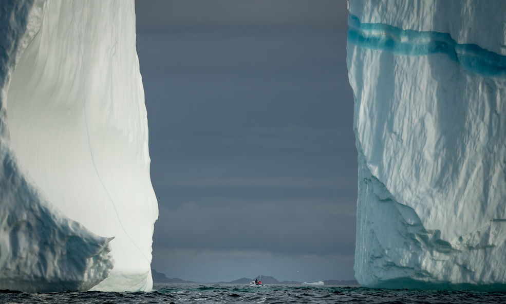 Two_iceberg_walls_and_a_tiny_boat_near_Kulusuk_in_East_Greenland_slider_1750933905.jpg